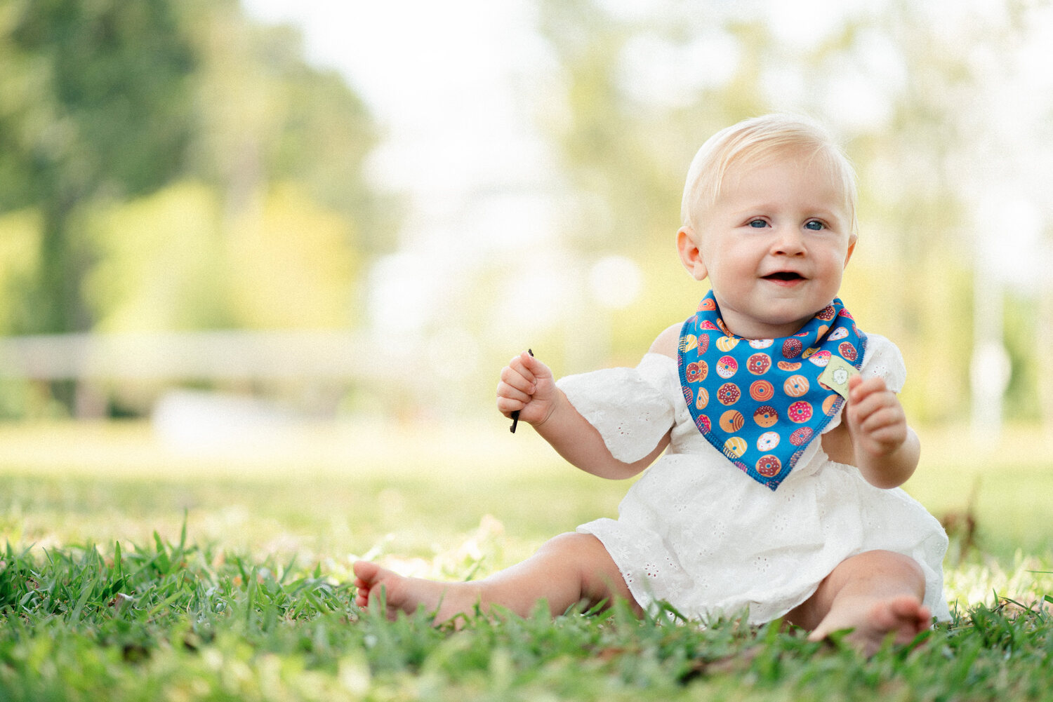 KeaBabies baby in a bandana bib sitting on the grass — lifestyle photography