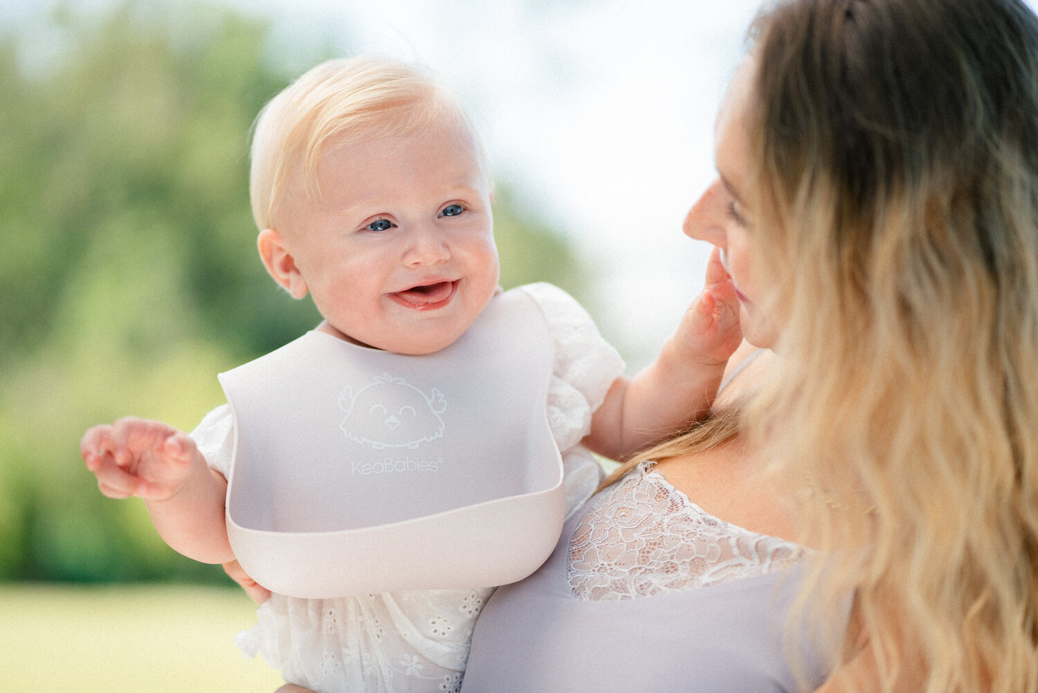 KeaBabies baby bib on a smiling baby with parent — lifestyle photography