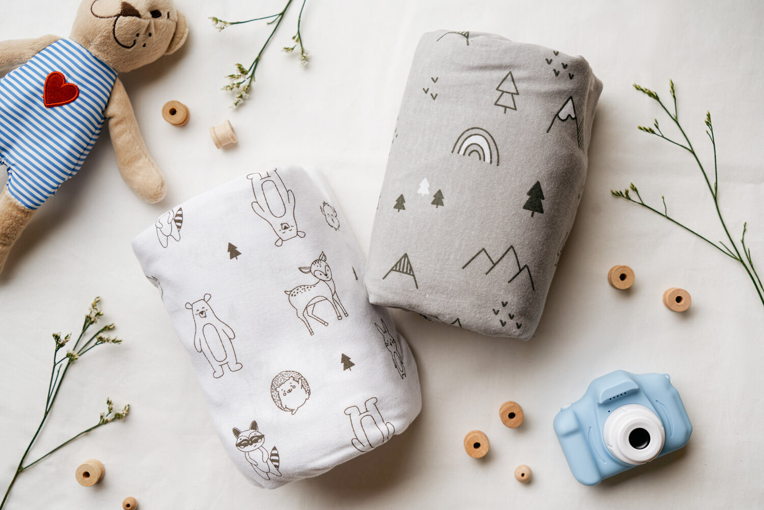 KeaBabies crib sheets flat-lay with toys — e-commerce product photography Singapore