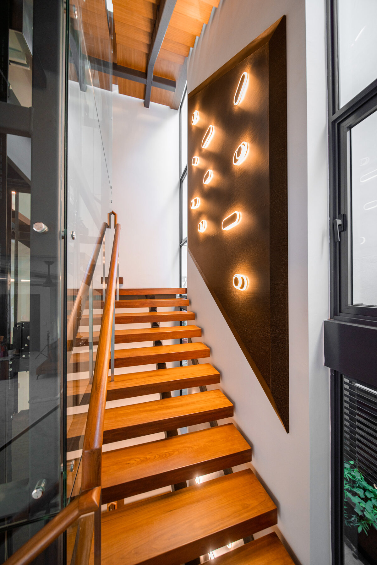 Luxury landed home floating timber staircase with sculptural feature wall — architecture photography
