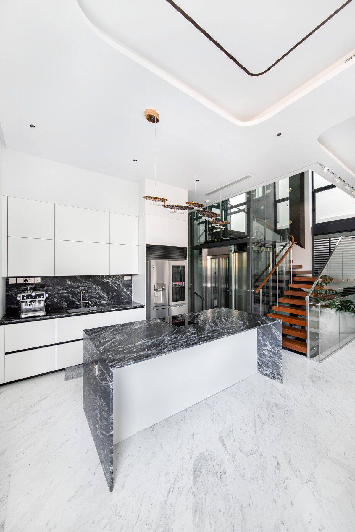 Luxury landed home marble kitchen island and floating staircase — interior photography Singapore