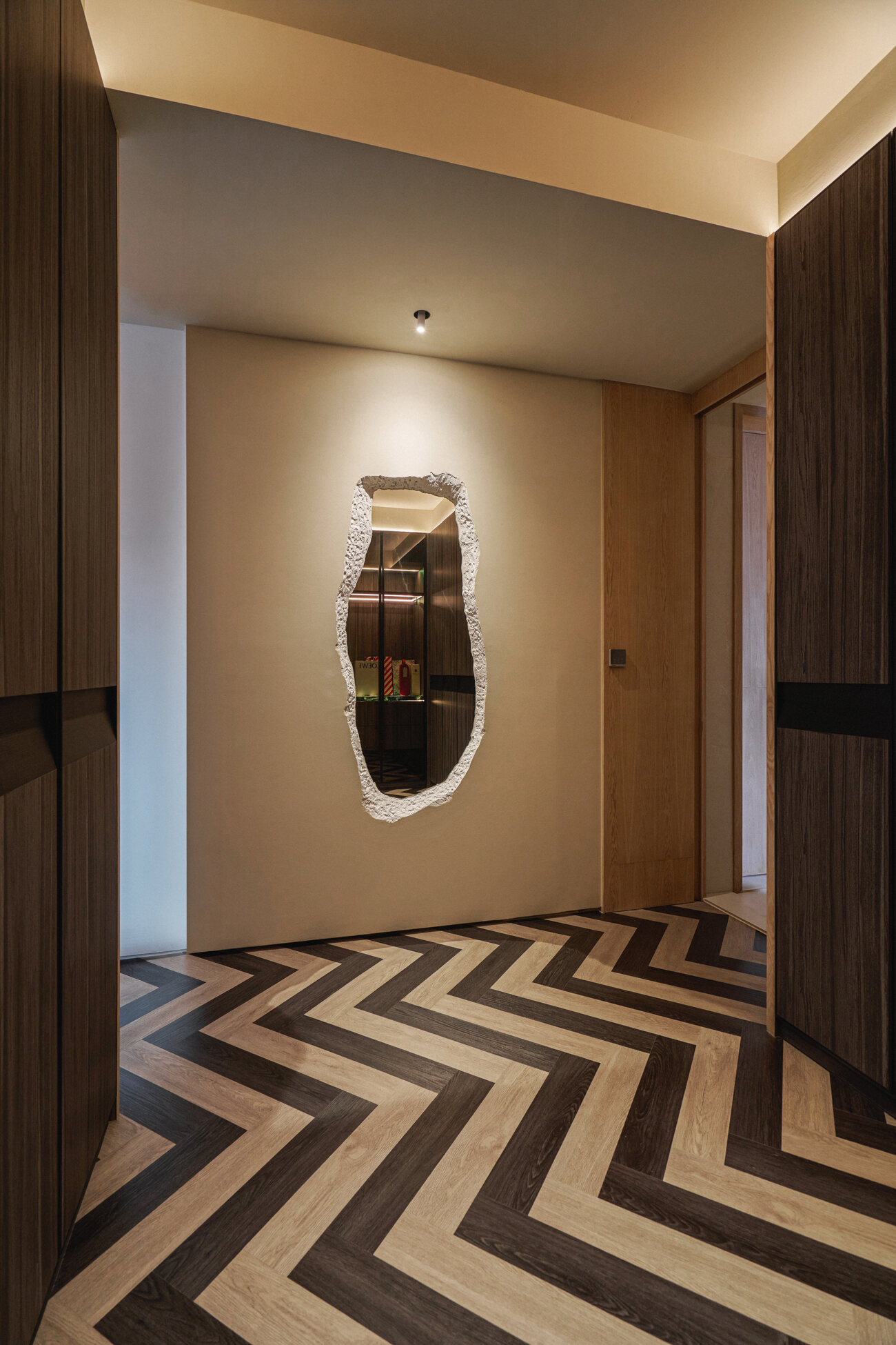 Telok Kurau residence entrance hallway interior photography — a sculptural pendant light above a chevron marble floor