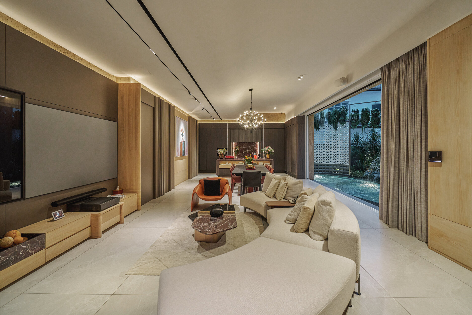 Telok Kurau residence living room interior photography — a curved sofa, feature wall and floor-to-ceiling glazing opening to the garden