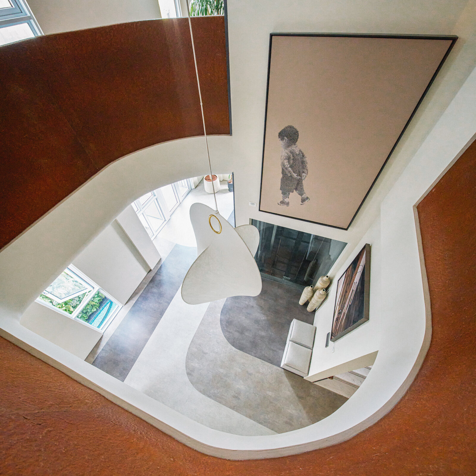 Telok Kurau residence architecture photography — an overhead view of the sculptural curved void in warm terracotta tones
